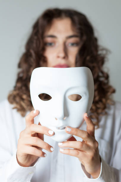 istock Woman Holding Mask Against White Background 1006889000
