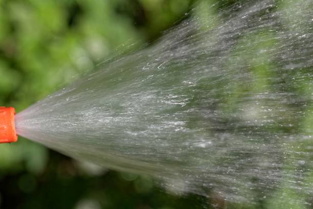istock Water jet from a hosepipe with a green background 1006891624