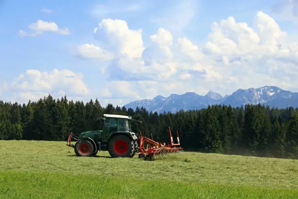 Mowing in summer on a field in Bavaria. Agricultural work in summer