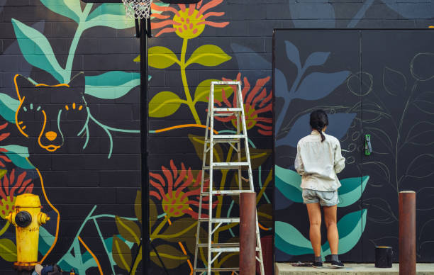 mural artista en el trabajo Artista pintando mural en barrio urbano