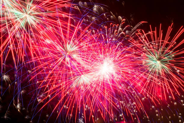 istock red pink bright salute in the night dark sky, beautiful splashes 1006940444