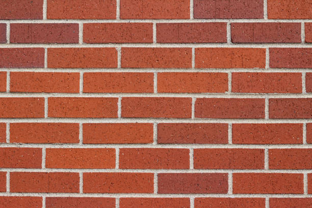 istock Red brown textured brick wall background in traditional running bond pattern 1006956882