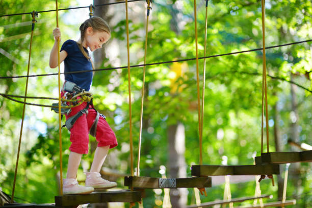 mała dziewczynka ciesząc się jej czas w parku rozrywki - tree skill nature horizontal zdjęcia i obrazy z banku zdjęć