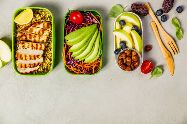 Healthy lunch in boxes Healthy meal prep containers: Couscous with grilled chicken breast, salad, avocado, berry, apple, nuts and dry dates. Keto, ketogenic diet, low carb, healthy food concept. Top view lunch box photos stock pictures, royalty-free photos & images