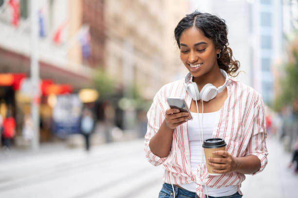 istock Woman on the street using her phone and drinking coffee 1006969034