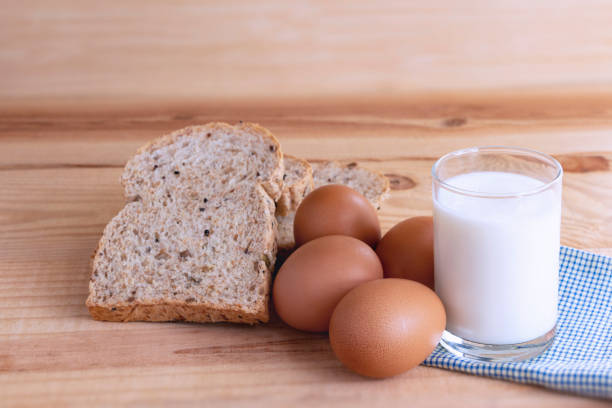 istock Prepare breakfast with eggs, milk, bread on a wooden table.  Milk and egg necessary for growth, health, and good condition. Copy space for your text. 1006984066