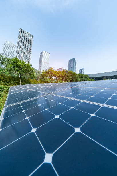 istock Ecological energy renewable solar panel plant with urban landscape landmarks 1006984084