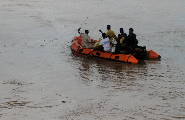Monsoon Flooding ODRF (Odisha Disaster Response Force) personals are seen at their boat as they petrol in the flood water of river Kuakhai, the branch river of Mahanadi after flood water enters into it outskirts of the eastern Indian state Odisha’s capital city Bhubaneswar. bhubaneswar stock pictures, royalty-free photos & images
