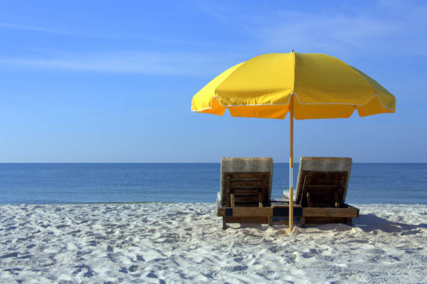Two Beach Chairs with Yellow Umbrella Two Beach Chairs with Yellow Umbrella beach umbrella photos stock pictures, royalty-free photos & images