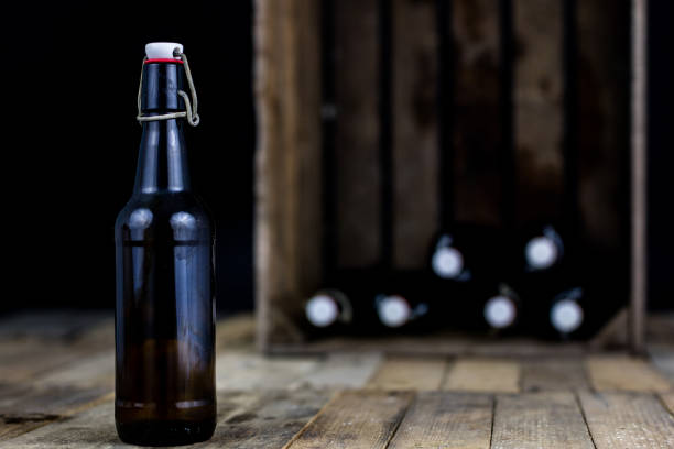 istock Old bottles in a wooden case. Drinks in old glass containers. Dark background. 1007043712