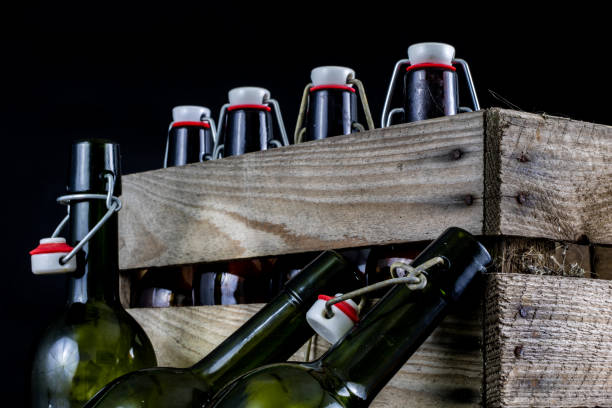 istock Old bottles in a wooden case. Drinks in old glass containers. Dark background. 1007044114