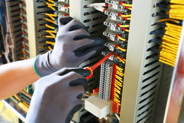 ジャンクションボックスの電気端末と技術者によるサービス。plcによるサポートプログラムと制御機能のためのコントロールパネルに電気デバイスをインストールします。技術者による定期� - electricity ストックフォトと画像