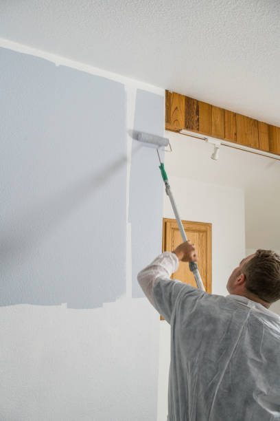 istock Man painting interior of home with roller 1007047422