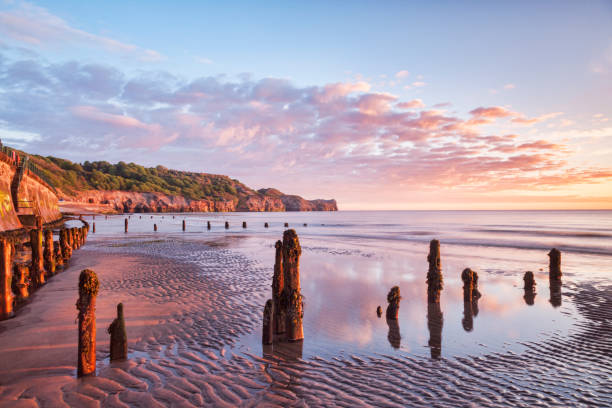 日の出 sandsend 海岸ウィットビー ノース ・ ヨークシャー イギリス - beach sunrise waterbreak sea ストックフォトと画像