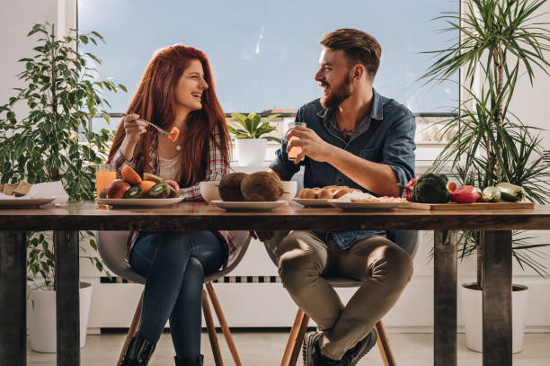 istock Young happy couple communicating during their meal at dining table. 1007053482