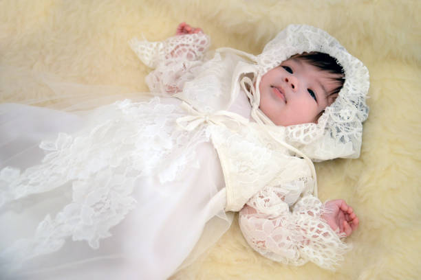 Christening / Baptism of a baby girl A beautiful Asian baby girl, dressed in a traditional white lace gown and Christened through the Coptic Orthodox Christian tradition at old church. baptism photos stock pictures, royalty-free photos & images