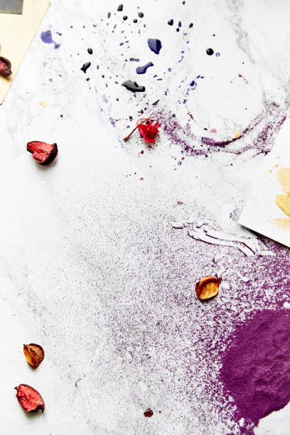 istock Overhead view of messy artist's workplace with color splashes. White background. 1007087560