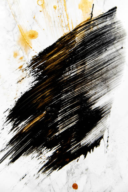 istock Abstract mashed stain of black color paint on white background with golden spots. 1007087570