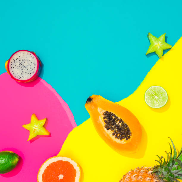 Creative tropical layout with tropical fruit and colorful vivid papers. Abstract colors art background. Minimal summer concept. Flat lay.