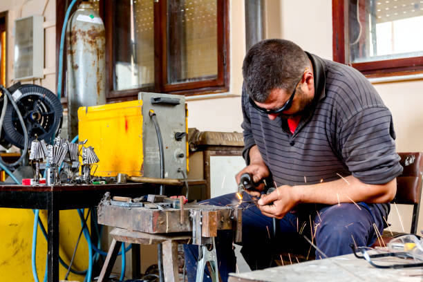 istock Artist is making figure by welding few metal wires in his workshop, barehande 1007091428