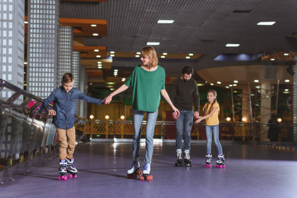 istock parents and kids skating on roller rink together 1007094272