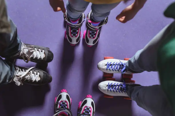 partial view of family in roller skates standing on roller rink