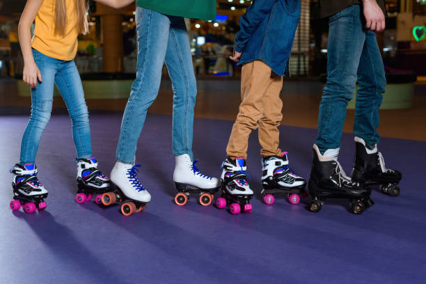 partial view of parents and kids skating on roller rink together partial view of parents and kids skating on roller rink together roller rink stock pictures, royalty-free photos & images