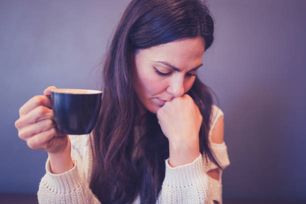 istock Worried young woman sitting in a cafe  drinking coffee, using mobile phone 1007094906