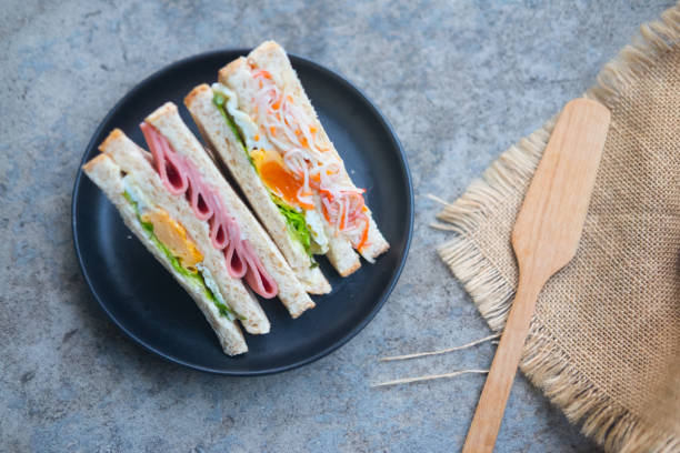 istock aSliced sandwiches cut with different filling - ham, salad, egg, bacon, whole grain bread 1007098048