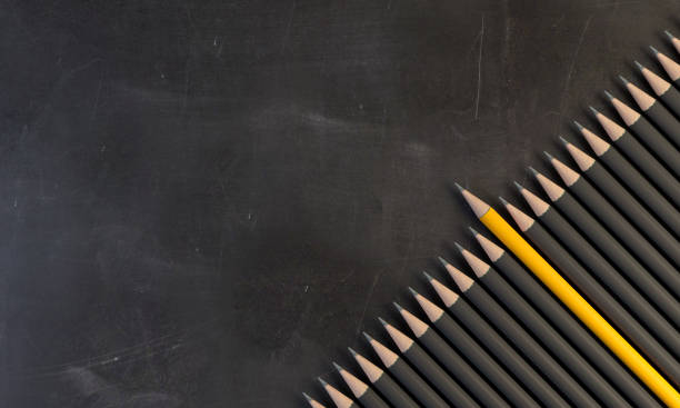 Pencil holder and ruler  in front of black chalkboard with Pythagorean theorem. Front focus