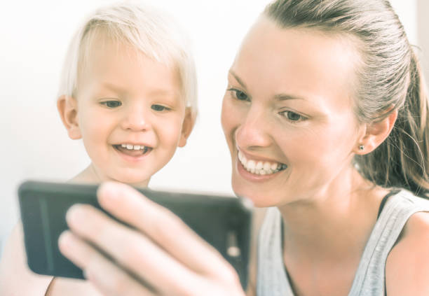 istock Happy mother and her son using smartphone mobile 1007108062