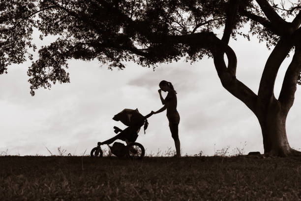 Tired mother suffering from post natal depression. Stressed sad mother pushing stroller. postpartum depression stock pictures, royalty-free photos & images