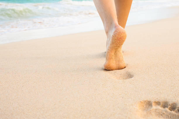 istock Woman walking on the beach 1007108610