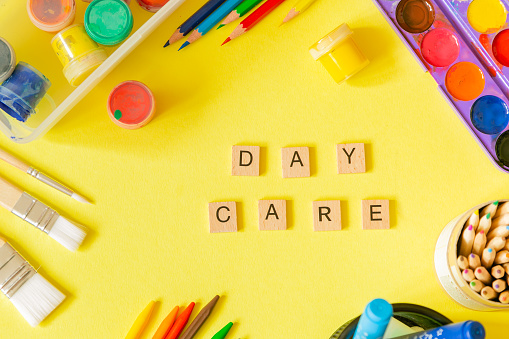 Day care concept - art supplies and toys on bright background, top view