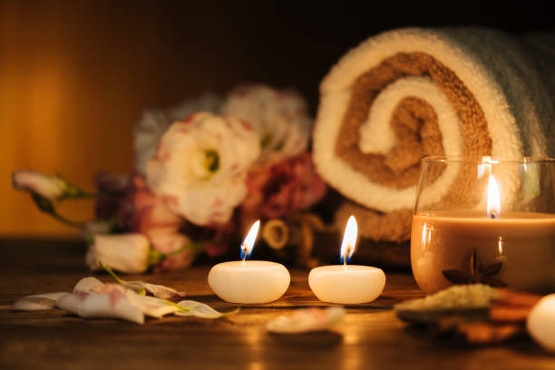 istock Spa still life with aromatic candles, flowers and towel. 1007122866