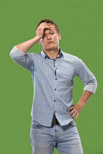 istock Let me think. Doubtful pensive man with thoughtful expression making choice against green background 1007123484