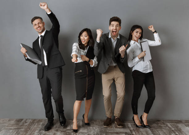 istock happy multicultural business people with folders and notebooks standing at grey wall 1007146078
