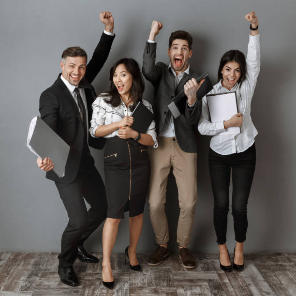 istock happy multicultural business people with folders and notebooks standing at grey wall 1007147582