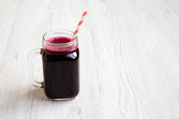 istock Beetroot smoothie in glass jar mug over white wooden background, low angle. Copy space. 1007148600