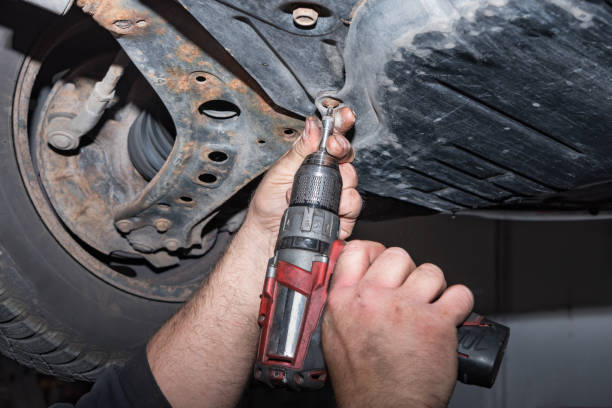 istock mechanic at work. Attach a screw with the cordless screwdriver 1007148612