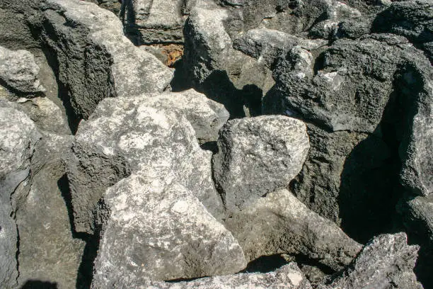 Photo of Huge rocks eroded by sea lit by midday sun.