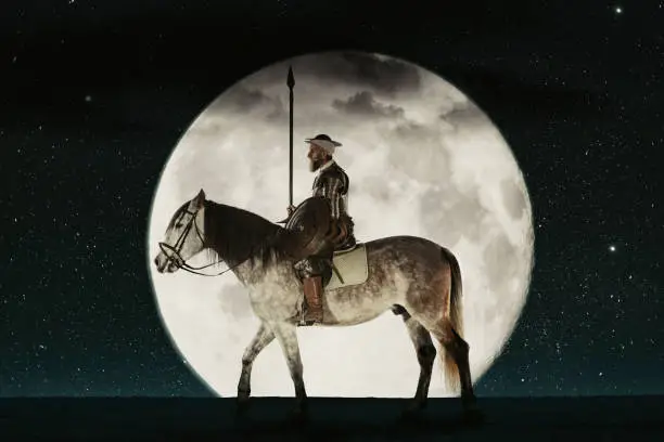 Photo of Don Quixote riding his horse against full moon