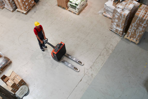 worker working with pallet truck in storage