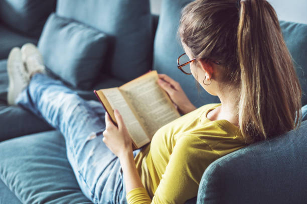 la giovane donna sta leggendo un libro - legge foto e immagini stock