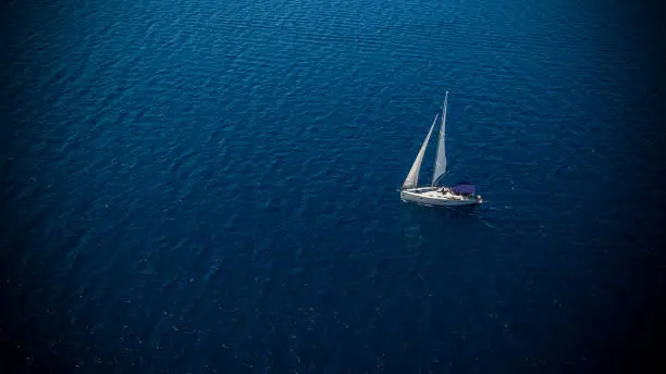 Sailing boat on open water, aerial view. Active life style, water transportation and marine sport.