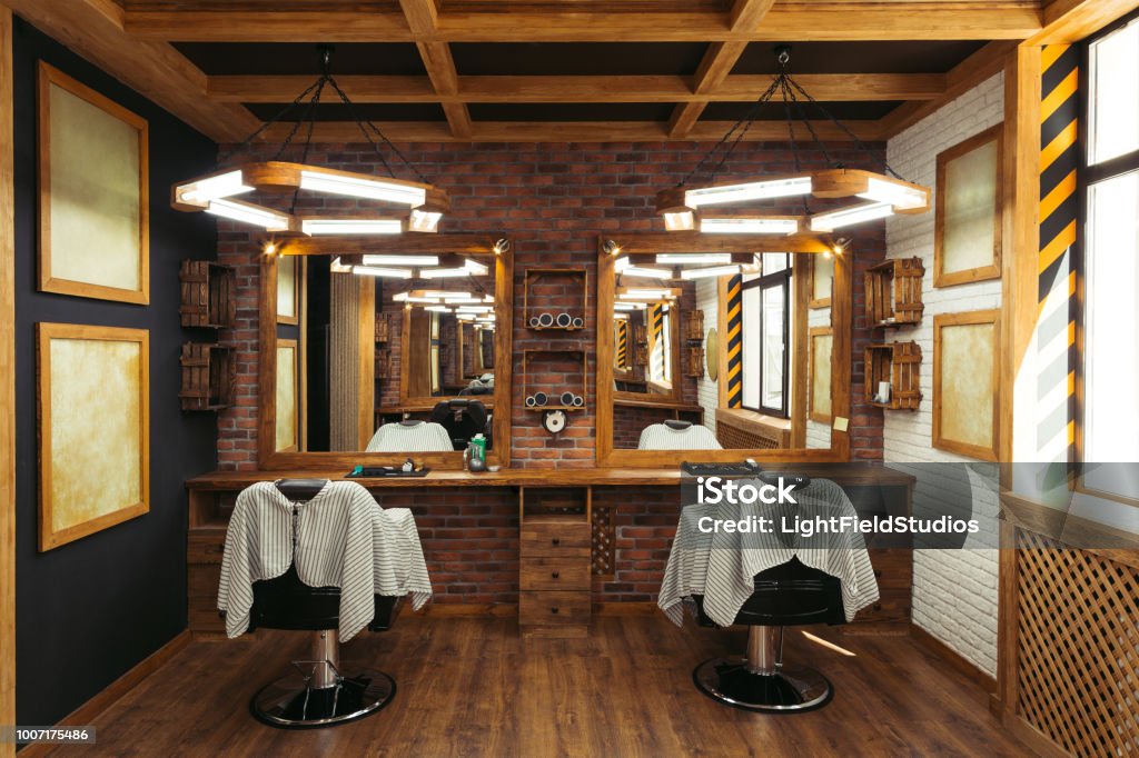 interior moderno de peluquería vacíelo con sillas, espejos y lámparas - Foto de stock de Barbero - Peluquería libre de derechos
