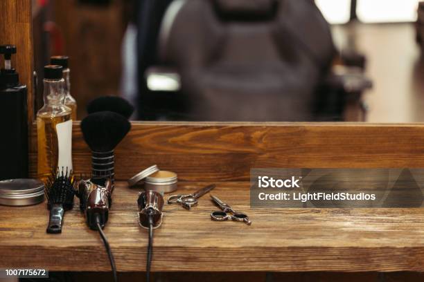 Barber Tools On Wooden Shelf And Mirror In Barbershop Stock Photo - Download Image Now