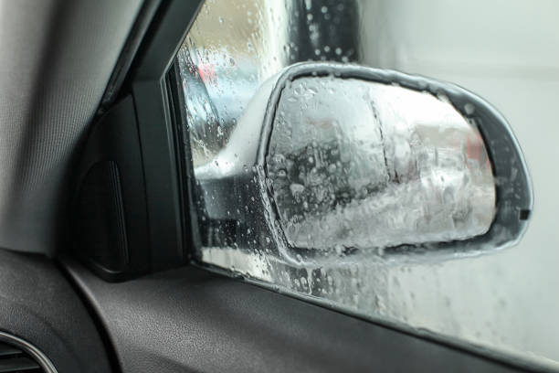 istock View from inside the car, looking at side mirror, wet from water and soap when being washed in carwash. 1007179334