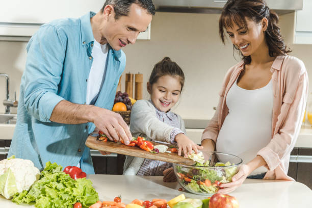 istock happy smiling family making salad together at kitchen 1007186290