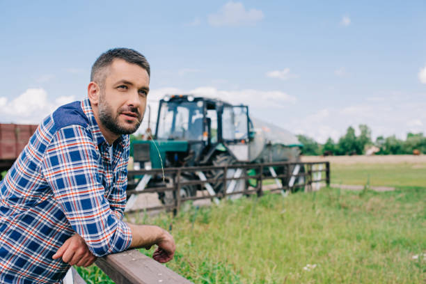 istock pensive middle aged farmer leaning at railing and looking away at farm 1007188994